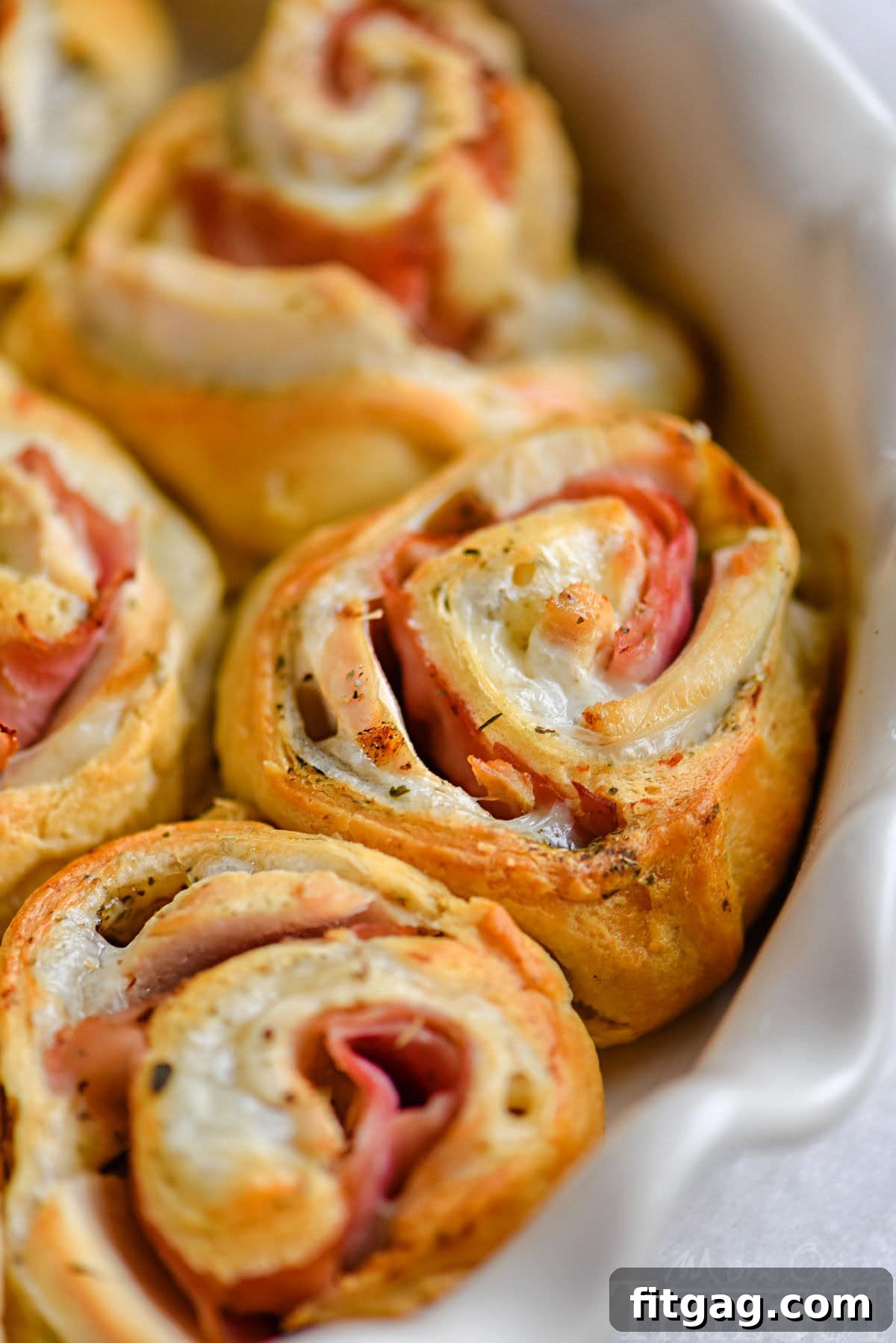 Golden brown Chicken Cordon Bleu Crescent Rolls arranged beautifully in a white pie dish, ready to be served.