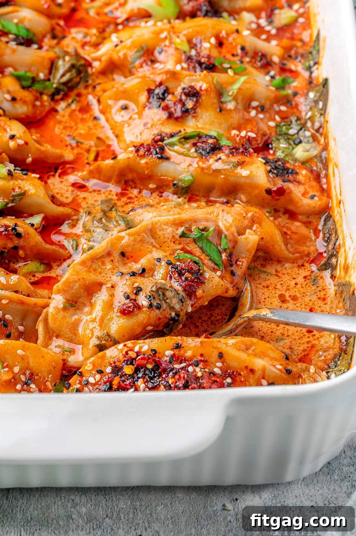 A pristine white baking dish brimming with perfectly baked viral dumplings, glistening with sauce and ready to be served, capturing a moment of culinary perfection.