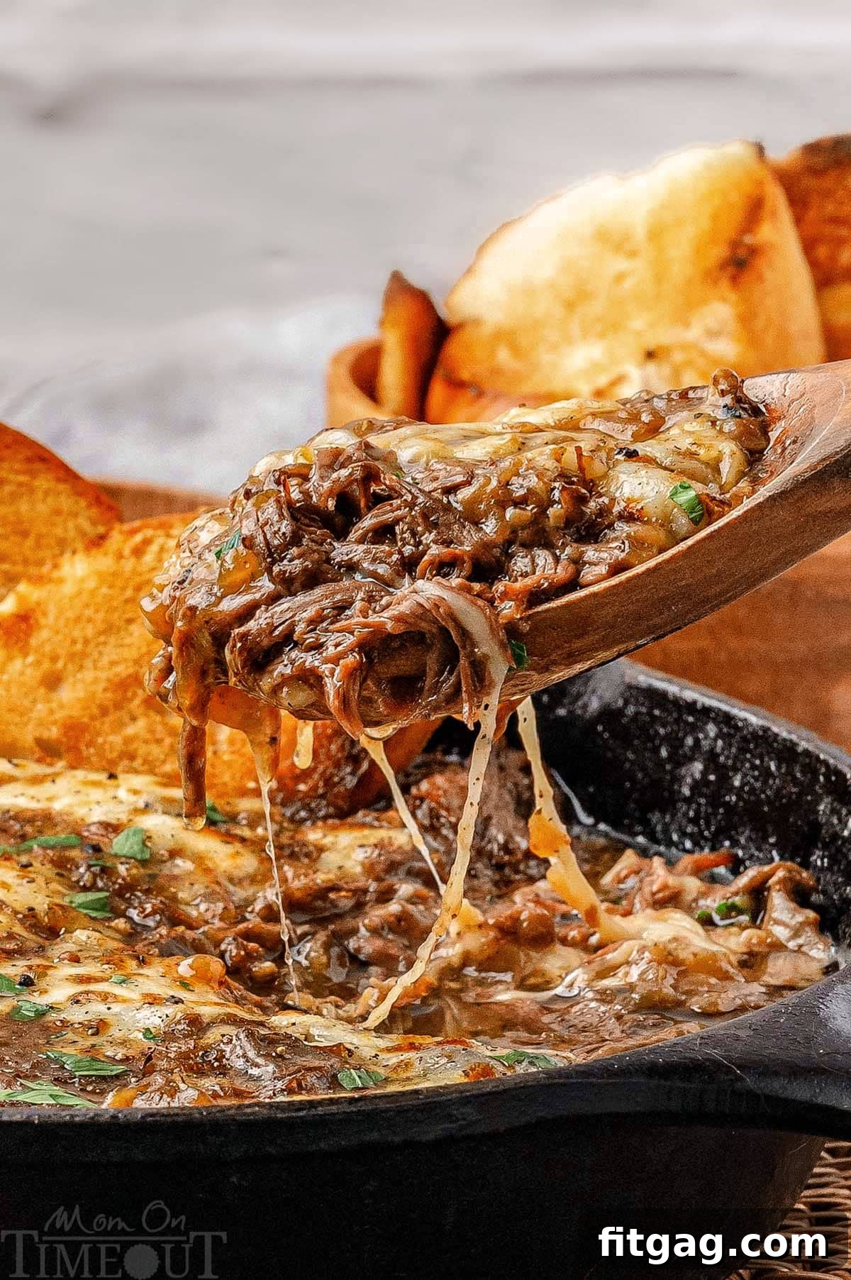 Slow-Cooked French Onion Beef 6 French onion soup pot roast being lifted out of the pan after the roast has been shredded.