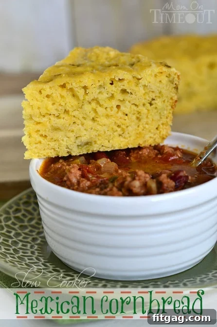 A plate of Slow Cooker Mexican Cornbread, garnished and ready to eat, served with a side of chili.
