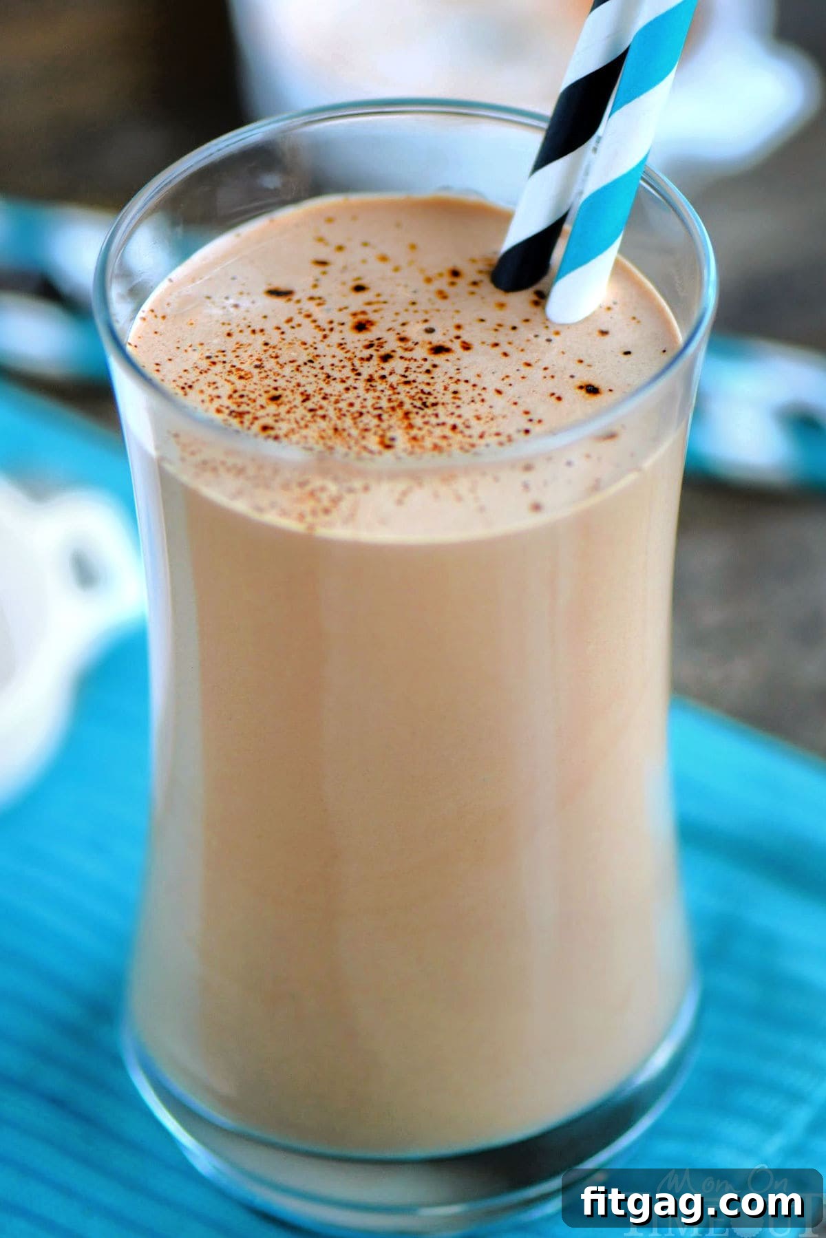 Espresso Power Shake 6 Up close look at coffee protein shake recipe in a tall glass ready to be enjoyed. You can see a sprinkle of espresso powder on top of the shake.