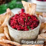Large hand made pottery bowl with fresh cranberry salsa in it. The bowl is surround with cinnamon sugar chips.