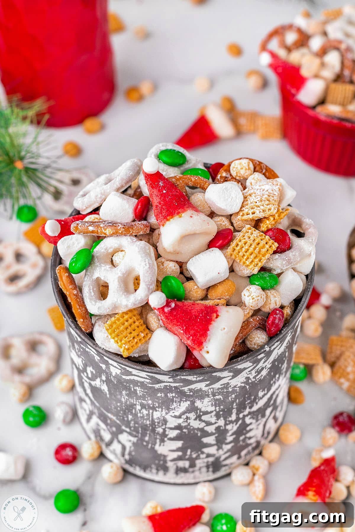 Metal bucket filled with santas snack mix including cereals, pretzels and candy. 