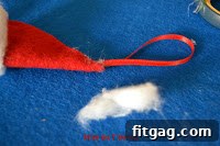 Attaching the black felt nose, thread whiskers, and googly eyes