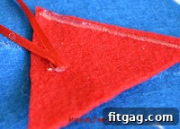 Preparing the ribbon hanger and red felt for the Santa hat