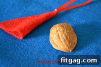 Adding cotton trim to the base of the Santa hat on the walnut