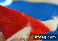 Preparing a small cotton ball for the pom-pom on the Santa hat