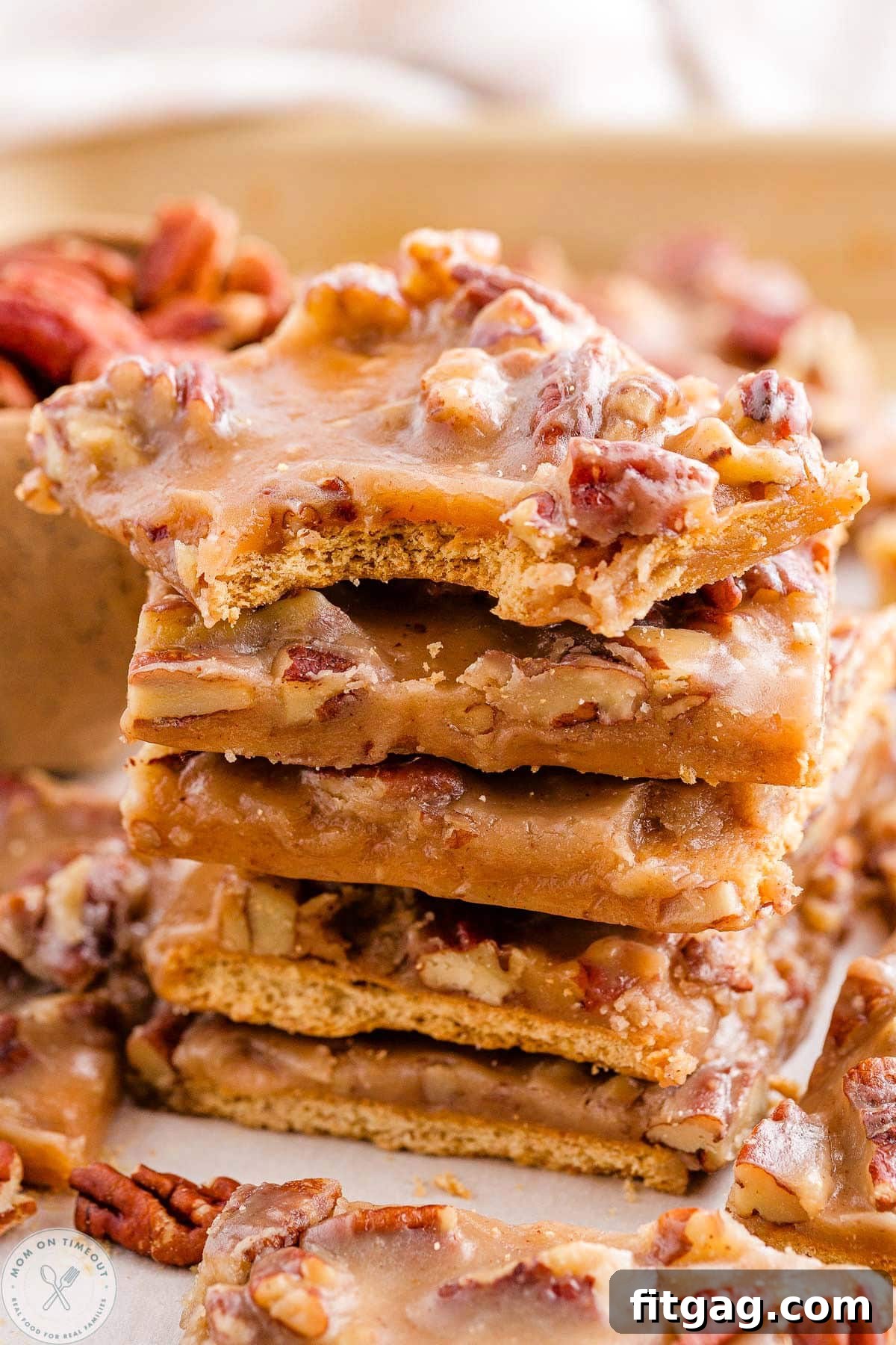 Toasted Pecan Brittle 4 Stack of pecan pie bark with the top piece showing a bite taken, revealing the crispy graham cracker and caramel layers.