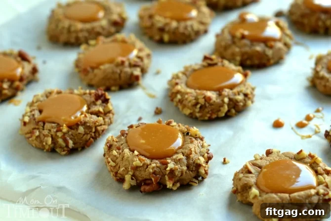 A tray of freshly baked Caramel Spice Thumbprint Cookies with glistening caramel centers.