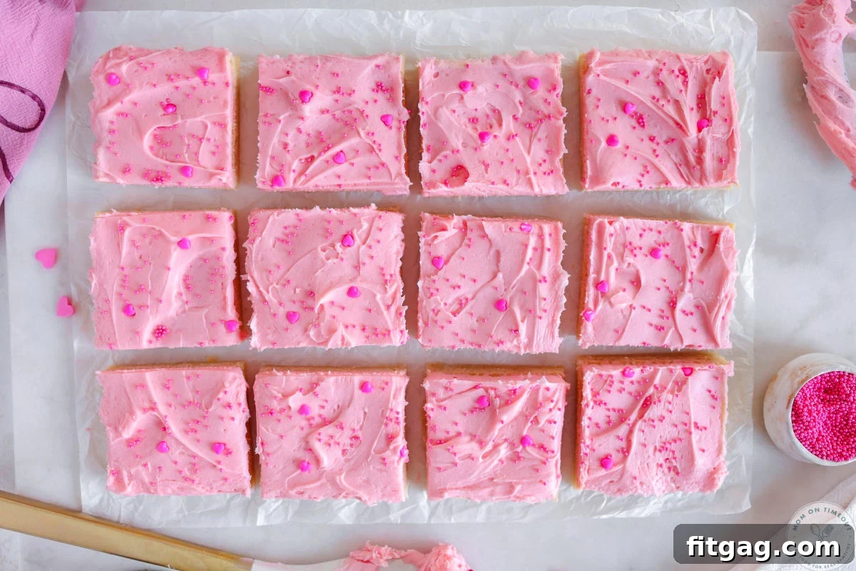 Sweetheart Sugar Cookie Bars 9 A wide shot of delightful Valentine's Day sugar cookie bars, neatly cut into perfect squares and arranged on white parchment paper, ready to be served.