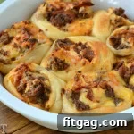 Finished Bacon Cheeseburger Pizza Pinwheels in a baking dish, golden and cheesy.