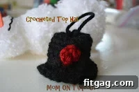 Crocheted hat for a pom pom snowman next to the assembled snowman body