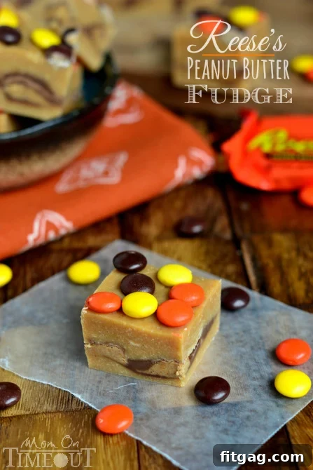 A perfectly sliced square of Reese's Peanut Butter Fudge, topped with Reese's Pieces, showcasing its creamy texture.