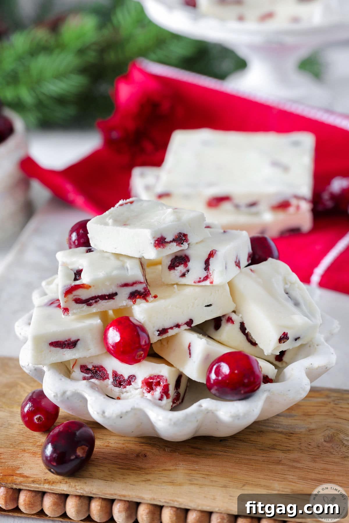 Small white bowl filled with small squares of cranberry white chocolate fudge. 