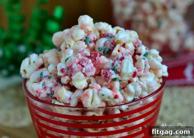 A wide shot of Peppermint Crunch Popcorn spread out on a sheet of waxed paper, allowing the white chocolate and peppermint coating to cool and set before serving.