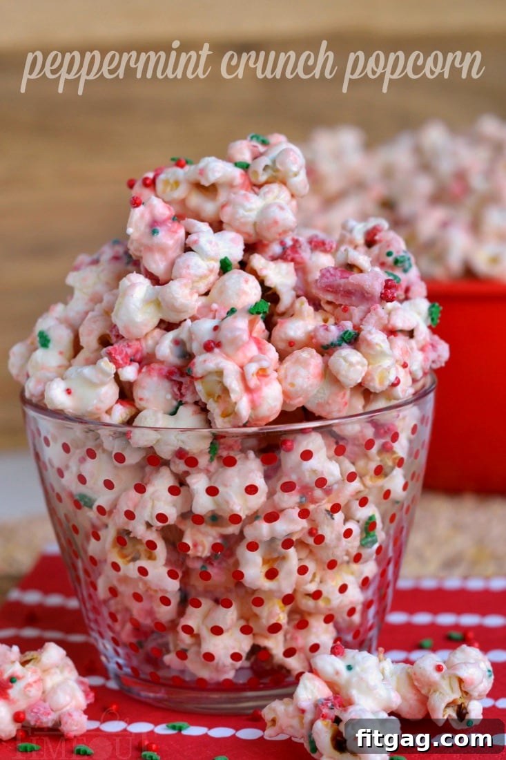 A large, rustic ceramic bowl overflowing with fresh Peppermint Crunch Popcorn, lightly drizzled with white chocolate and sprinkled with red and green sprinkles.