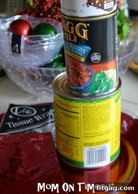 Empty cans wrapped in festive wrapping paper, ready to be used as stands.