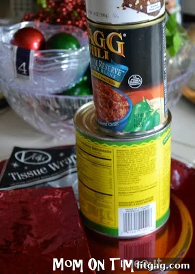 Empty cans wrapped in festive wrapping paper, ready to be used as decoration stands