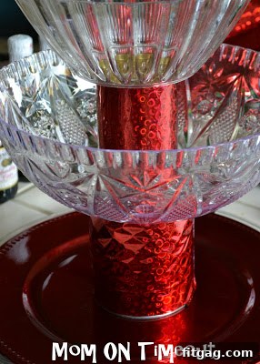 Tiered stand assembled with wrapped cans and plastic bowls.