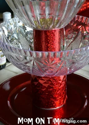 Tiered display stand created by stacking wrapped cans and plastic plates
