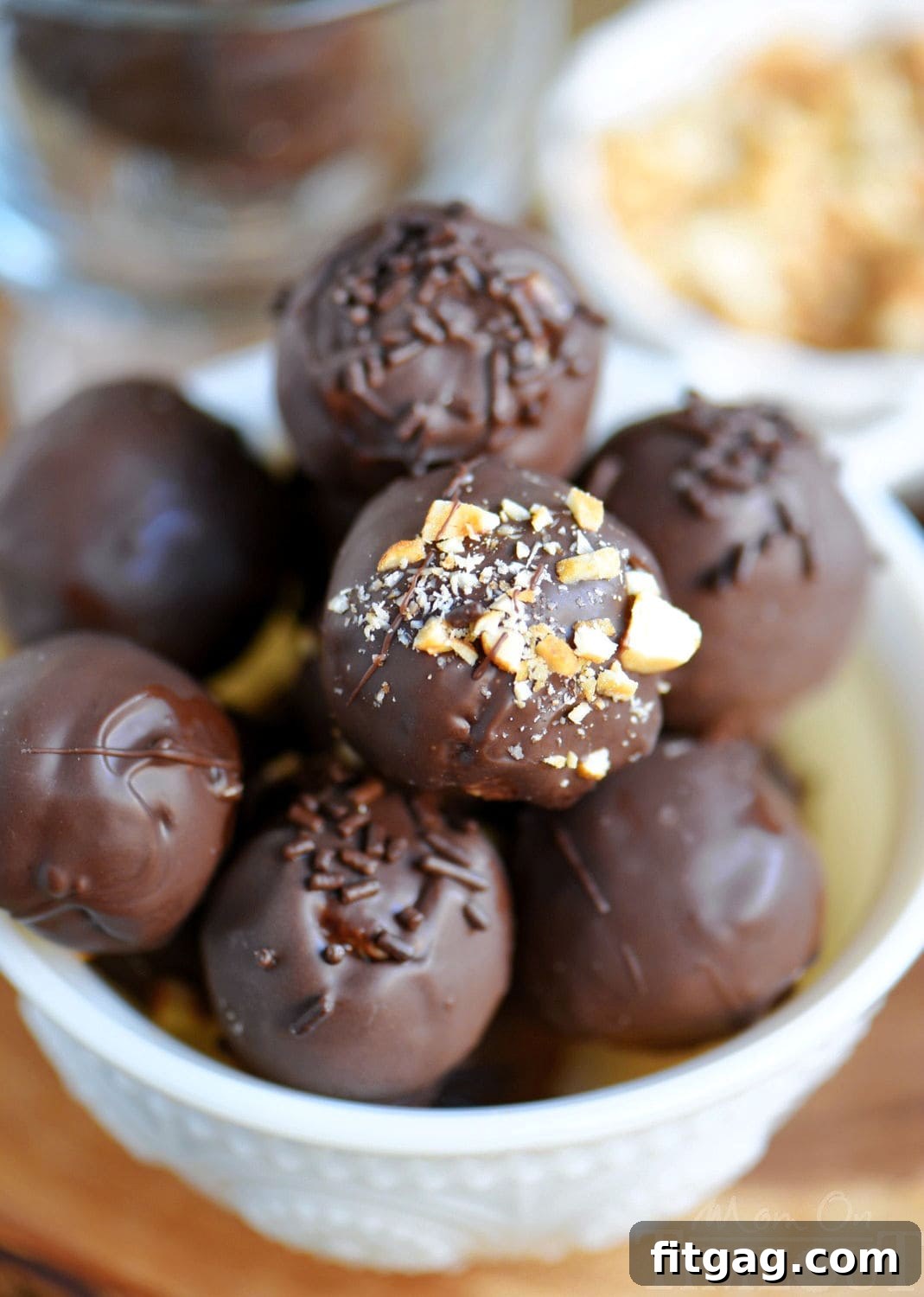 whole chocolate peanut butter balls in a white glass bowl ready to be enjoyed.