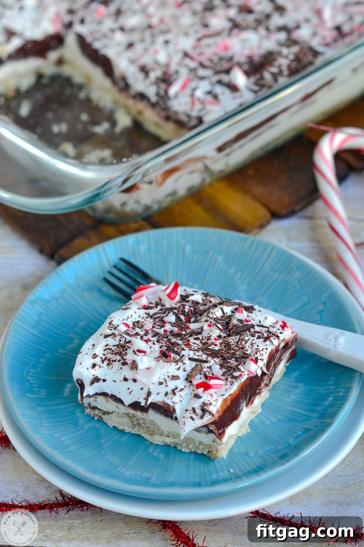 An overhead angled shot of a single serving of peppermint lush on a round blue plate, with the remaining dessert in the background.