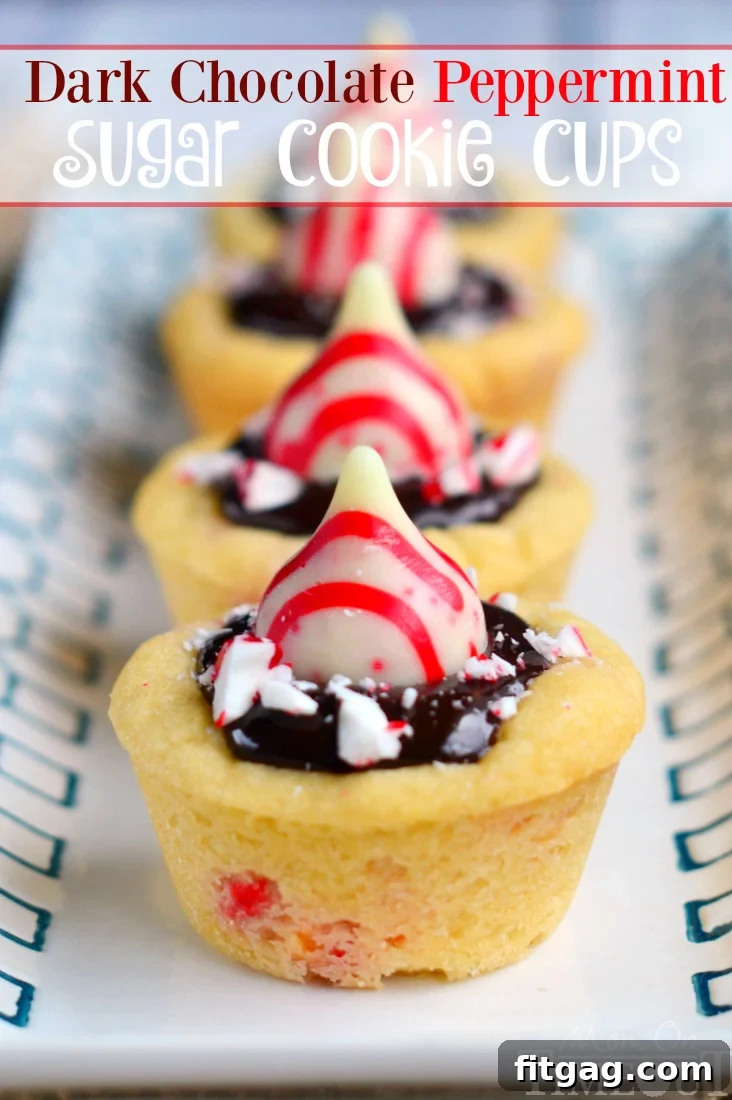 Dark Chocolate Peppermint Sugar Cookie Cups filled with chocolate ganache and topped with festive Candy Cane Hershey's Kisses, ready for holiday celebrations.