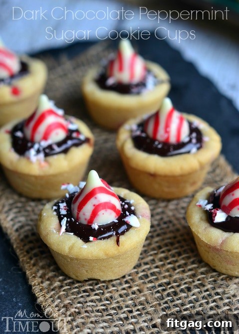 Dark Chocolate Peppermint Sugar Cookie Cups topped with Candy Cane Hershey's Kisses, ready to be served and enjoyed during the holiday season.