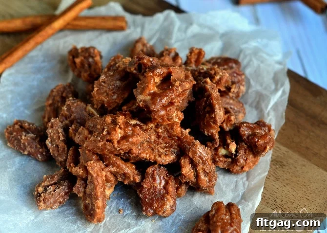 A wider shot of Sugar and Spice Pecans spread out on a baking sheet, showcasing their even coating and golden hue.