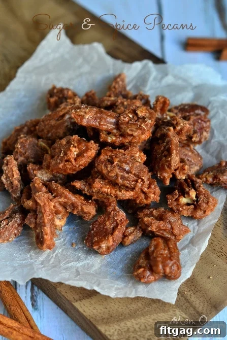 A vertical close-up of a bowl filled with glistening Sugar and Spice Pecans, ready for serving.
