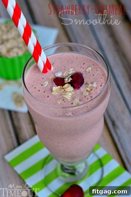 A refreshing Strawberry Oatmeal Smoothie with a bowl of oats and fresh strawberries in the background.