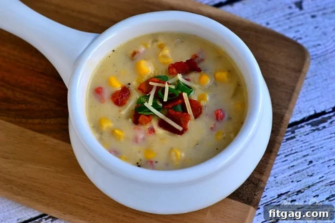 Close-up of Creamy Parmesan Corn Chowder garnished with fresh green onions and bacon bits.