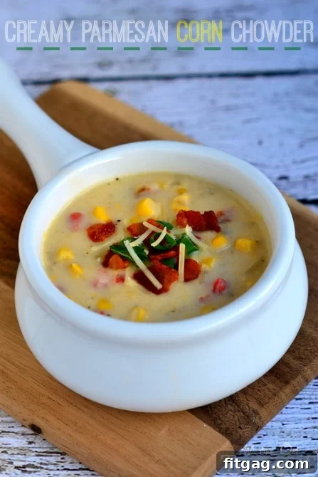 Bowl of Creamy Parmesan Corn Chowder with a spoon, highlighting its thick and hearty texture.