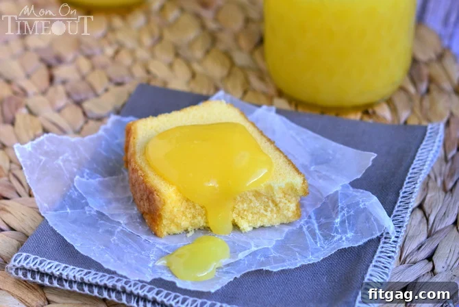 A delectable dollop of golden lemon curd gracefully resting on a slice of pound cake, presented on a rustic gray napkin, emphasizing its inviting texture.