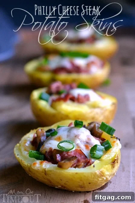 A baking sheet laden with prepared potato skins, each generously filled with meat and cheese, ready for broiling.