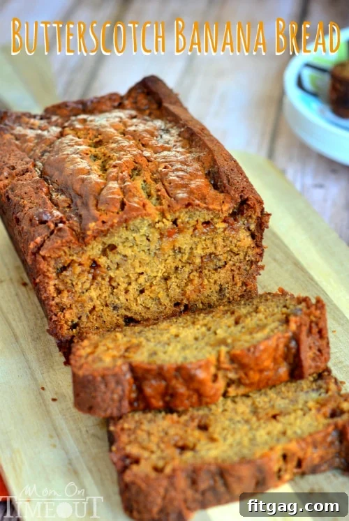 Overhead shot of a full Butterscotch Banana Bread loaf on a wooden cutting board, ready to be sliced.