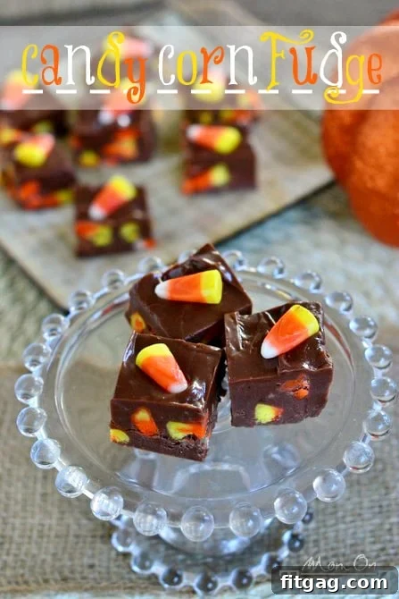 A large slab of finished Candy Corn Fudge with a knife, ready to be cut into individual servings for a Halloween party.