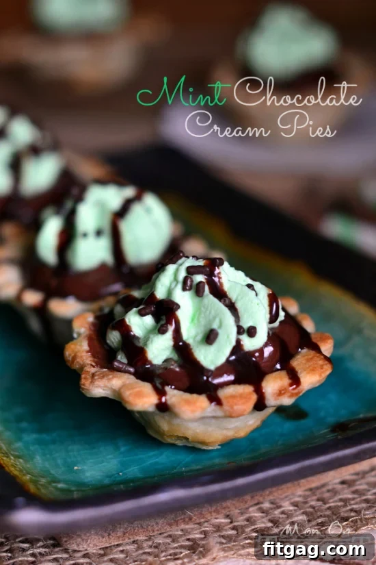 Close-up of a Mini Chocolate Mint Cream Pie, showing the layers of golden crust, dark chocolate cream, and green mint whipped cream.