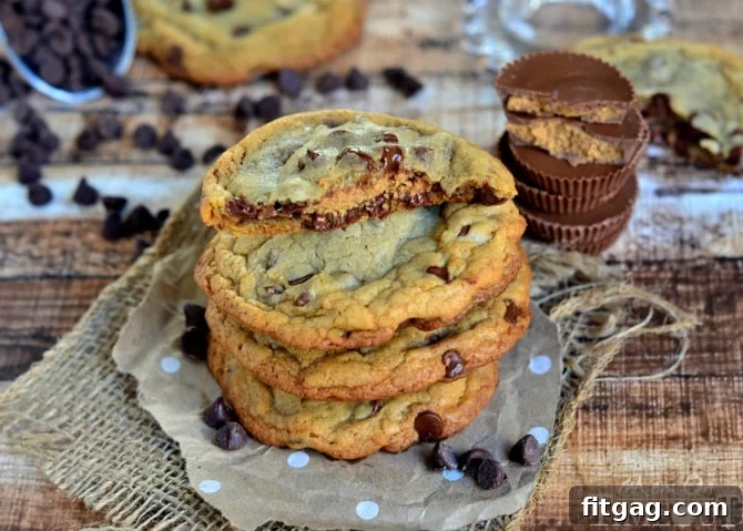 A close-up of a Reese's Stuffed Giant, Chewy Chocolate Chip Cookie with a golden-brown exterior, cooling on a rack.