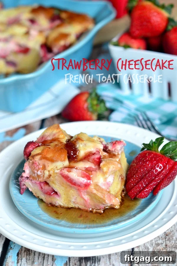Overnight Strawberry Cheesecake French Toast Casserole from MomOnTimeout.com A large serving of baked Overnight Strawberry Cheesecake French Toast Casserole on a plate, topped with fresh strawberries and drizzled with syrup.