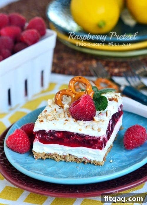 Raspberry Pretzel Dessert Salad | MomOnTimeout.com Delicious Raspberry Pretzel Dessert Salad with layers of crunchy pretzel crust, creamy filling, and vibrant raspberry gelatin.