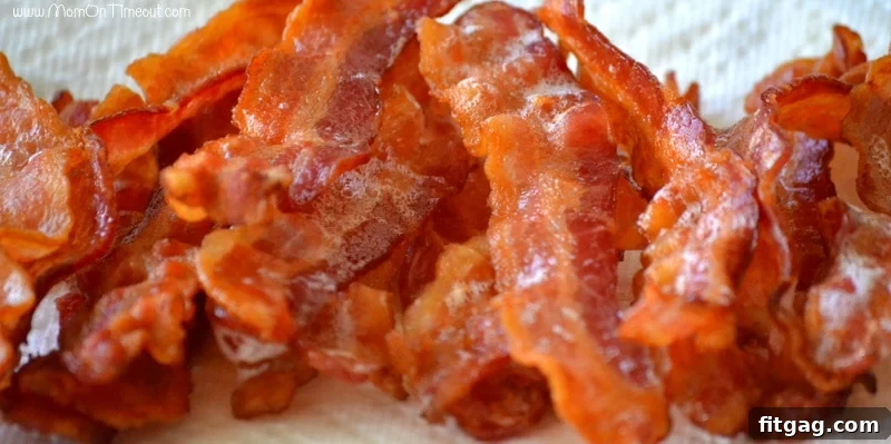 Crispy bacon strips cooling on paper towels.