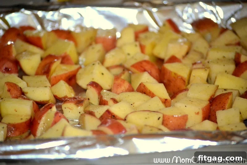 Golden brown roasted red potatoes on a foil-lined baking sheet.