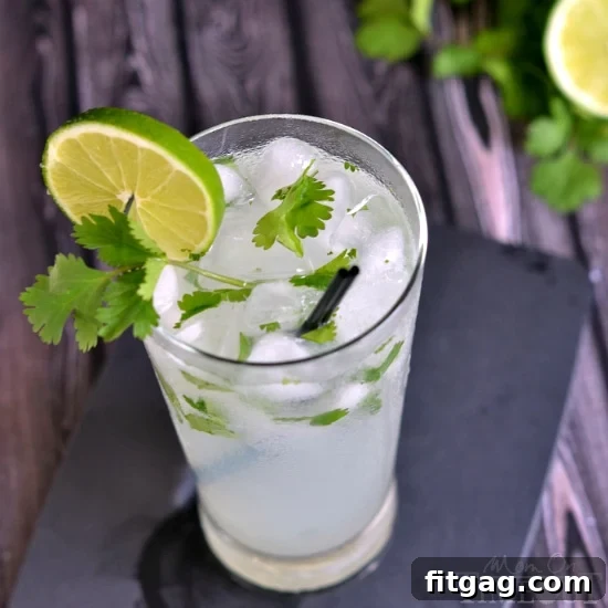 Coconut Lime Cilantro Quencher 6 Glass of Coconut Lime Cilantro Cooler with a straw and lime slice.