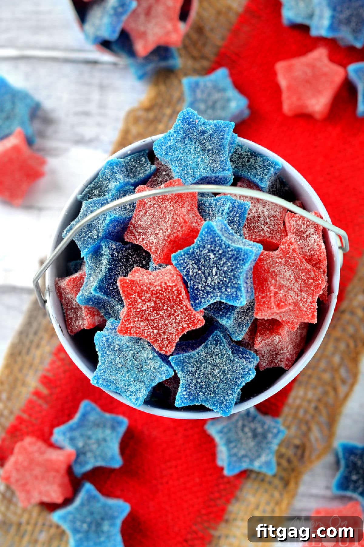 Overhead shot of red white and blue homemade gumdrops into red pail sitting on red burlap.