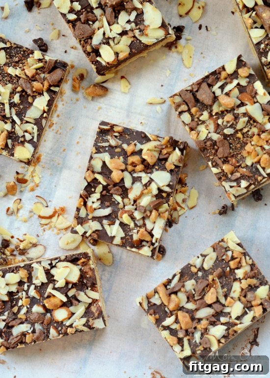 Buttery Toffee Blondies 4 A stack of three Toffee Cookie Bars, showing off their distinct layers of cookie, chocolate, and toppings from a slight angle.