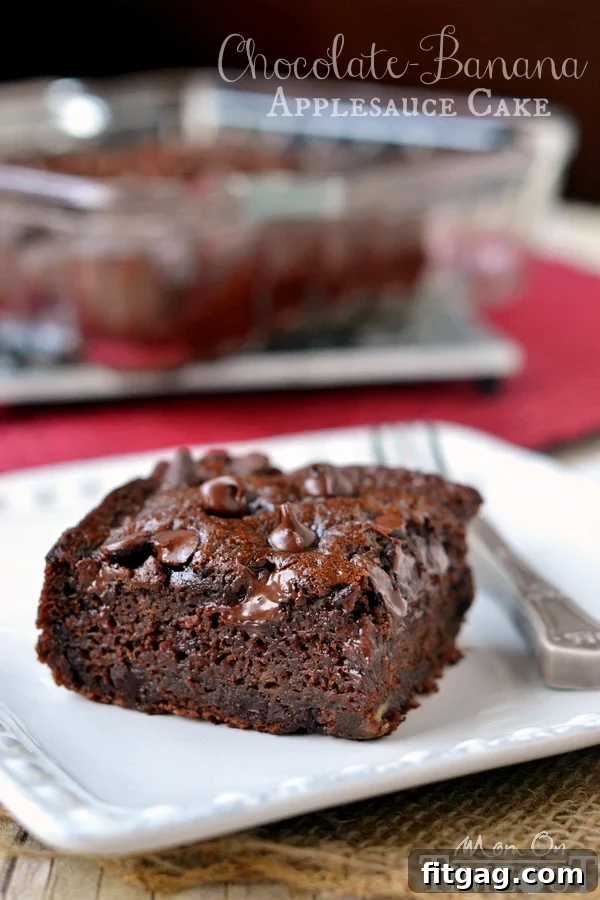 A slice of moist, rich Chocolate Banana Applesauce Cake, made without oil or butter, topped with melted chocolate chips. Perfect for a healthy snack!