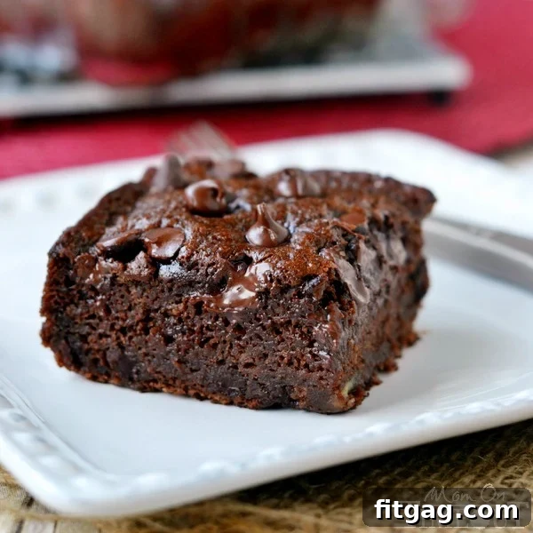 Close-up of a square Chocolate Banana Applesauce Cake in a baking dish, highlighting its moist texture and chocolate chips.