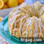whole zucchini bundt cake topped with orange glaze and sitting on green cake stand.