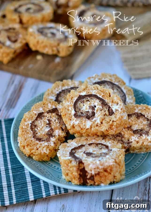 Close-up of S'mores Rice Krispies Treats Pinwheels, showing the distinct layers of marshmallow, chocolate, and graham cracker cereal rolled into a compact treat.